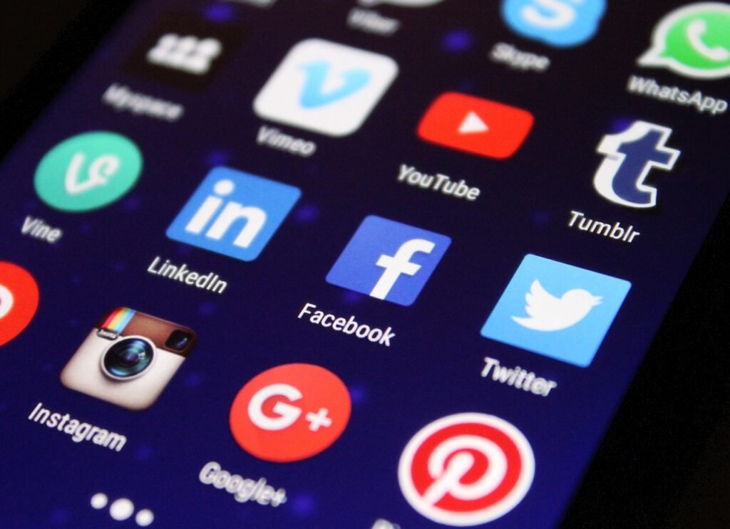 Close-up of a smartphone screen showing popular social media app icons such as Facebook, Instagram, LinkedIn, Twitter, YouTube, and WhatsApp, highlighting the impact of social media on modern business communication, marketing, and brand visibility.